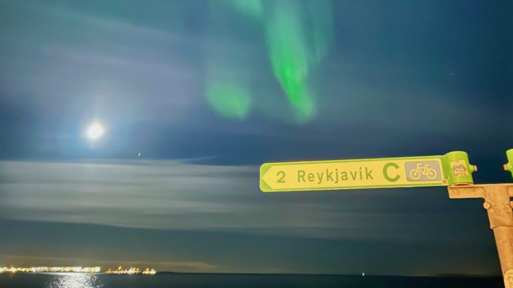 アイスランド、レイキャヴィークのオーロラ、満月と町あかり