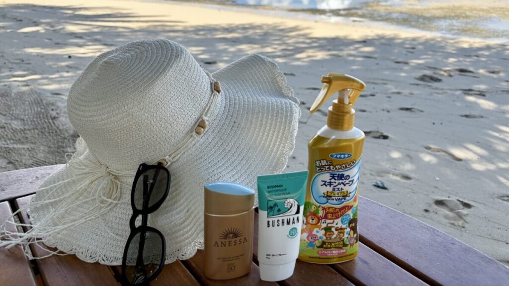 フィジーの海辺にて活躍したアイテムたちの写真（帽子、サングラス、日焼け止め、虫除けスプレー）